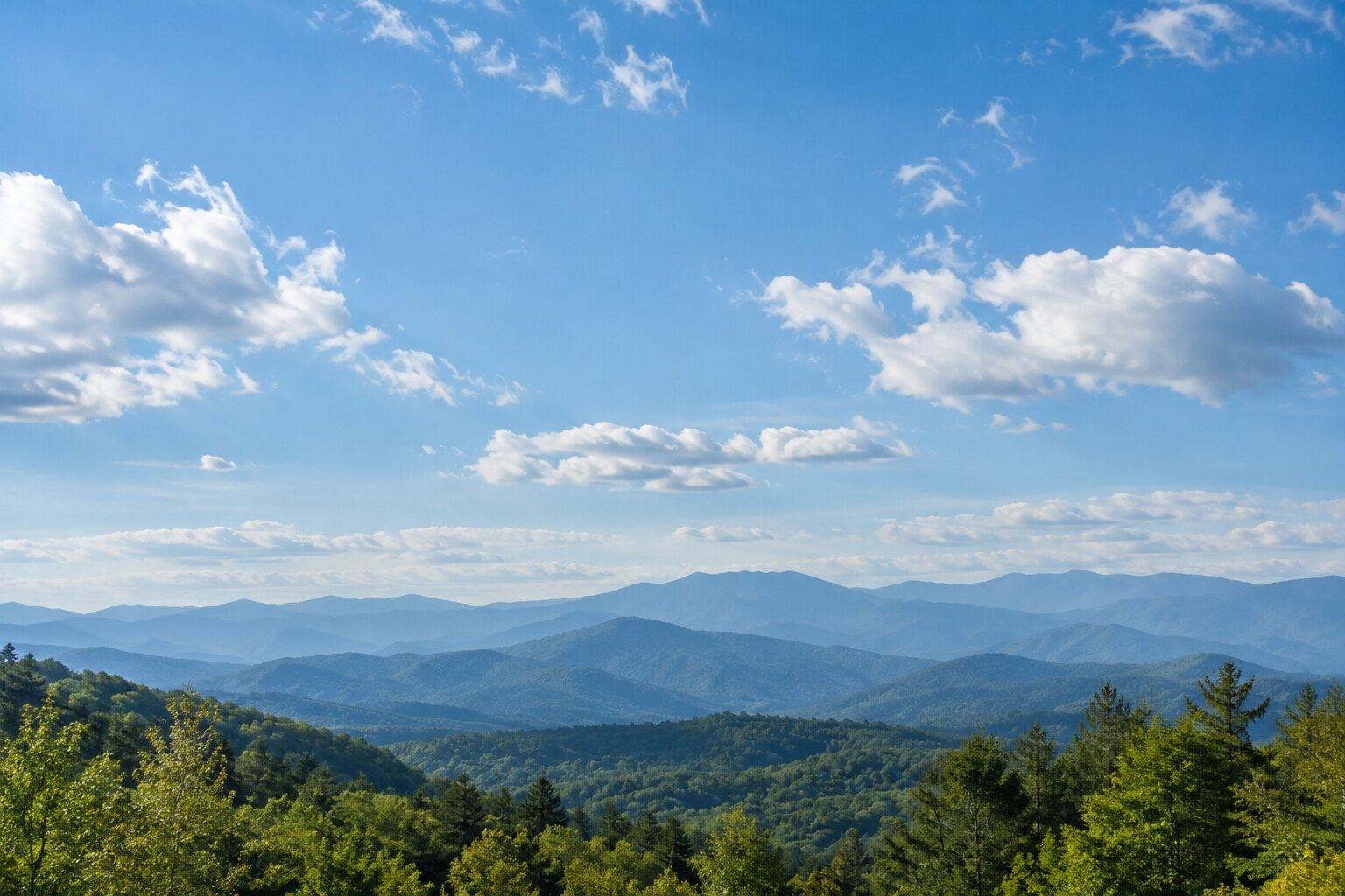 Nubes blancas sobre montañas azules a lo lejos